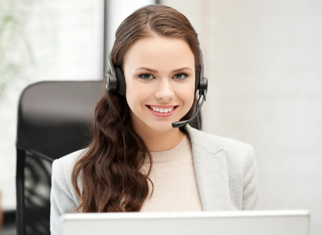 Female corporate employee smiling with a headset.